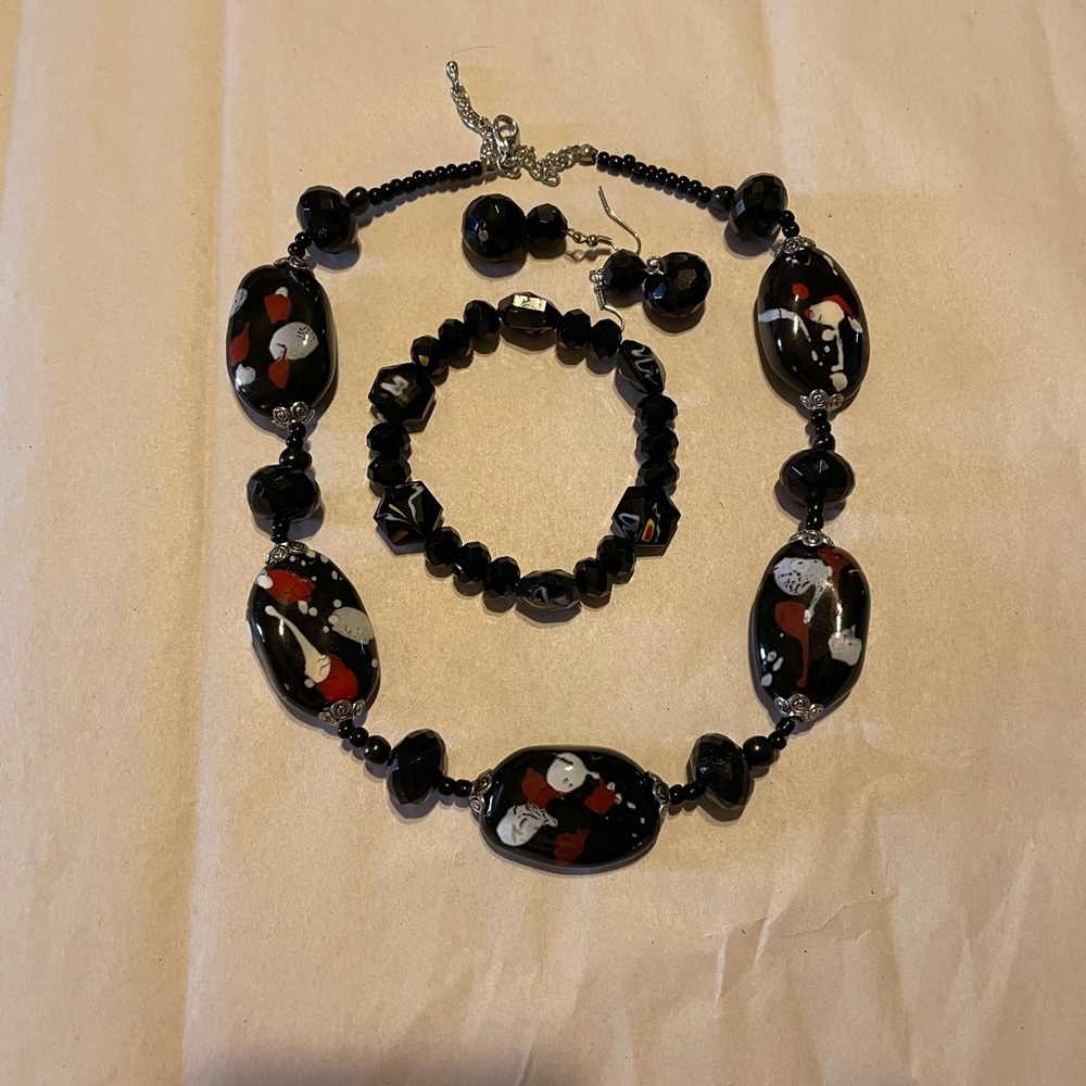 Black gemstone with splashes of white and red with earring and bracelet